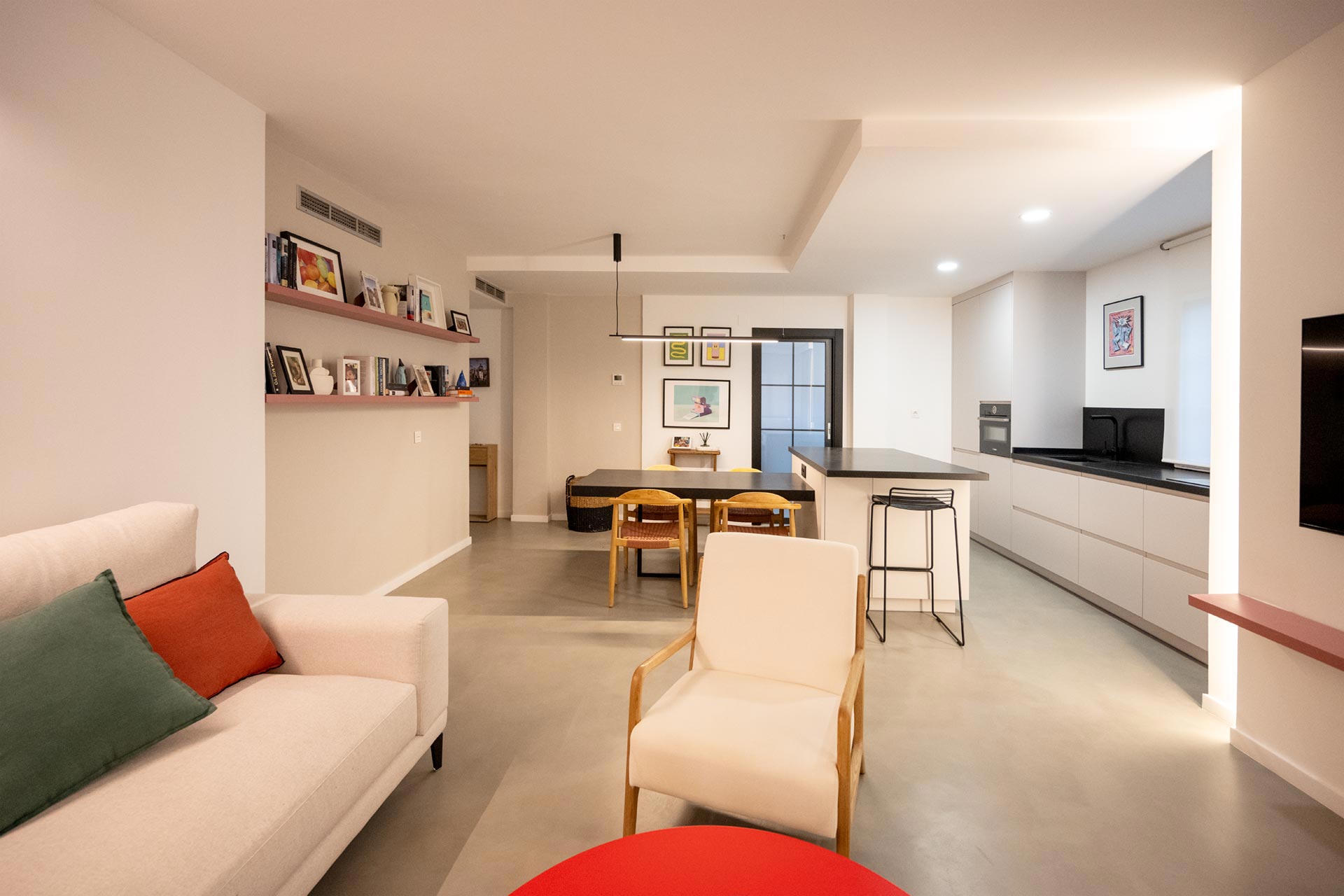 Sala de estar moderna con zona para sentarse, cocina en la parte trasera y mesa de comedor; Decorado con muebles minimalistas e iluminación brillante.